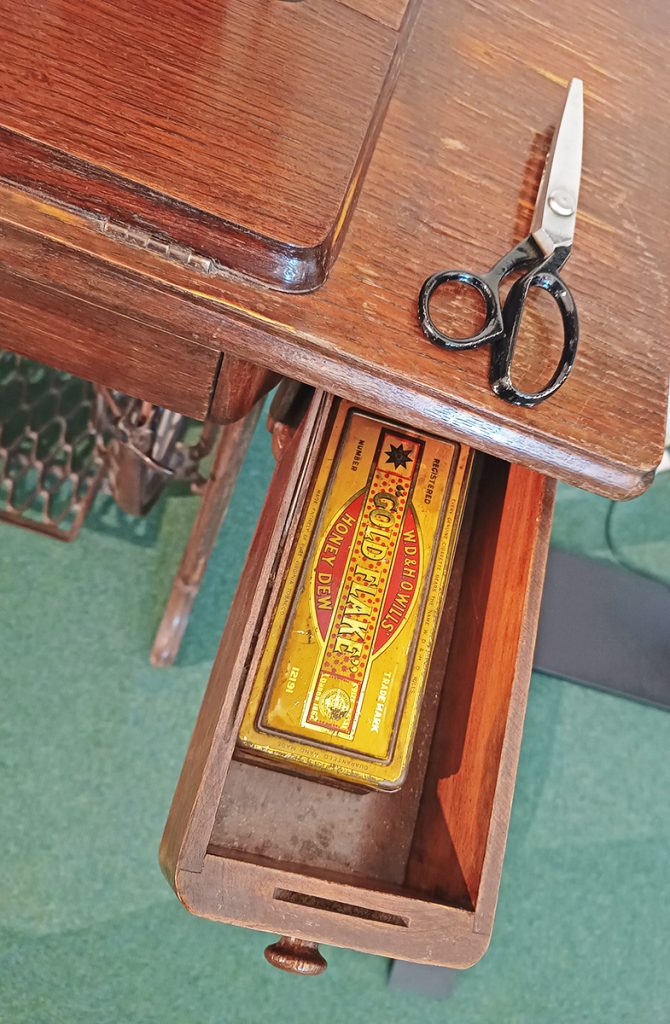 Singer Sewing Machine drawer with scissors and tin.